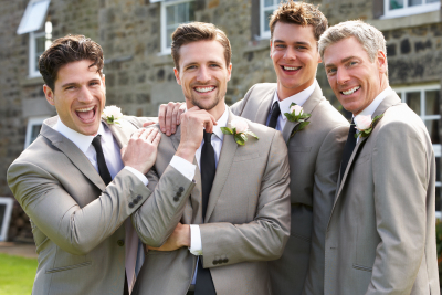 four gentlemen are smiling while attending at the wedding